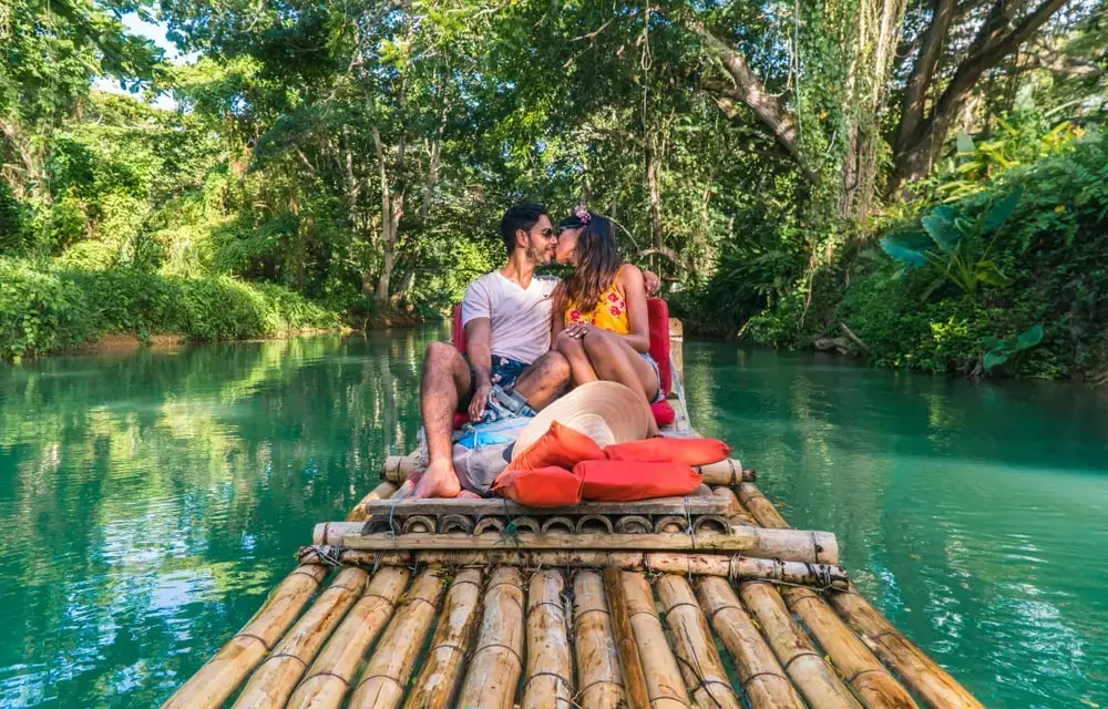 white couple on bamboo rafting at martha brae , jamaica